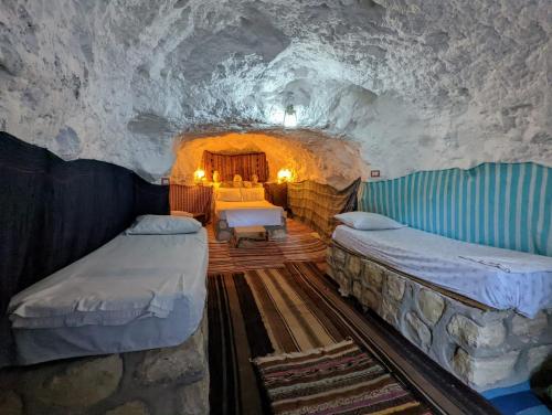 a room with two beds in a cave at Dar Fatma Toujane in Tūjān