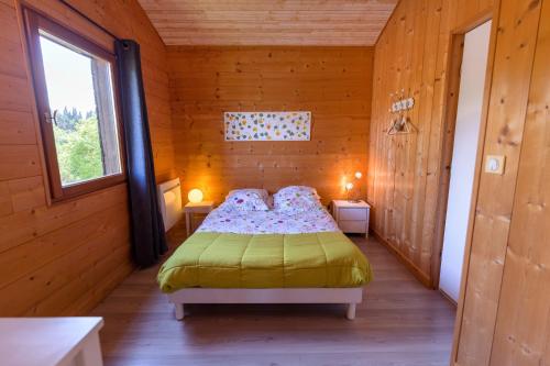 1 dormitorio con 1 cama en una habitación de madera en Chambre d’Hôtes Neptune Wood, en Arzens