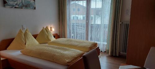 a room with a couch with pillows and a window at Pension Wildental in Sankt Martin bei Lofer