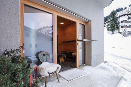 una puerta a una casa con nieve en el porche en Chalet Sonnblick, en Stuben am Arlberg
