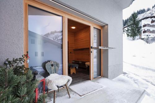 a door to a house with snow on the porch at Chalet Sonnblick in Stuben am Arlberg