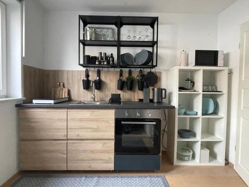 a kitchen with a sink and a black oven at Appartment 53qm im Architektenhaus - 2 Schlafzimmer mit Küche und Bad, nur 2min von A8 - ruhig und modern in Irschenberg