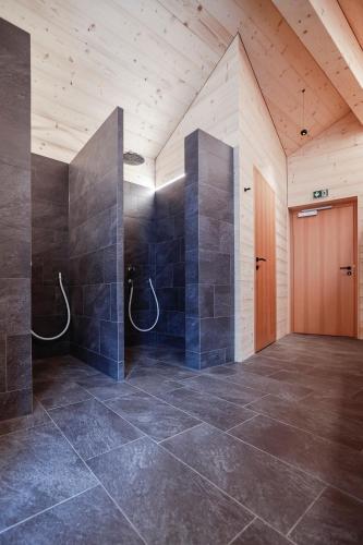 a large room with a shower with a wooden door at Chalet Sonnblick in Stuben am Arlberg