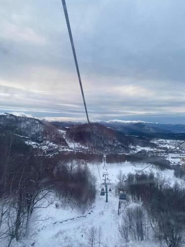 a ski lift in the air with snow on the ground at Orbi Palace Apartment in Bakuriani