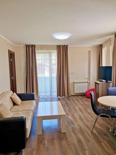 a living room with a couch and a table at Orbi Palace Apartment in Bakuriani