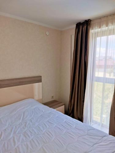 a bedroom with a bed and a window at Orbi Palace Apartment in Bakuriani