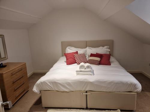 a bedroom with a large white bed with red pillows at Heritage Place by Select SA in Reading