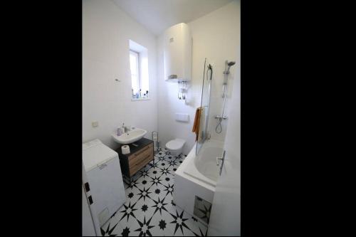 La salle de bains est pourvue d'un lavabo, d'une baignoire et de toilettes. dans l'établissement Wohnen im Grünen, à Graz