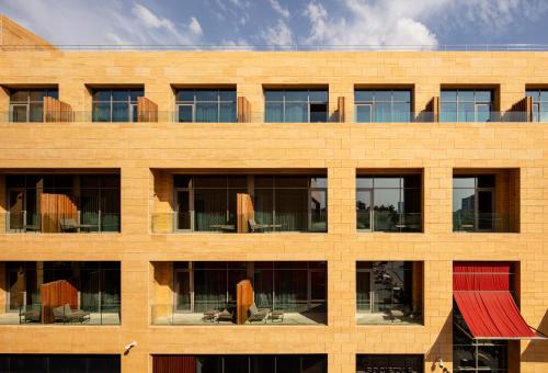 a brick building with windows and a red roof at SHIRVAN Hotel City Yard Jeddah in Jeddah