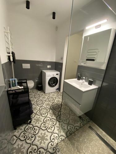 a bathroom with a sink and a washing machine at TWIN HOUSE in Gyál