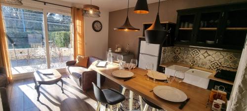 a kitchen and living room with a table and chairs at Le Refuge du Bugey in Saint-Sorlin-en-Bugey