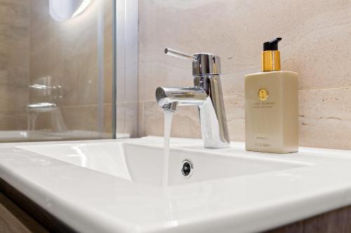 a bathroom sink with a bottle of soap on it at Hello Zeeland - Studio's Duinenburg 10 in Domburg