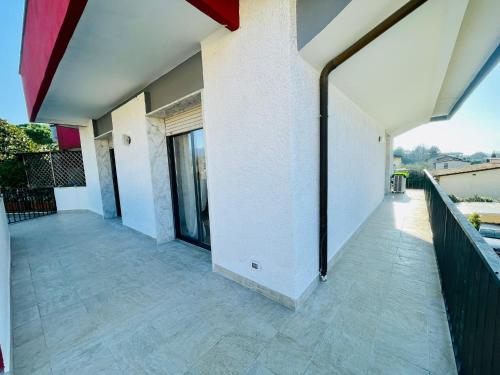 uma varanda vazia de uma casa com paredes e janelas brancas em Appartamento Gemma em Pietrasanta