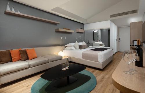 a hotel room with a bed and a couch at Cramim by Isrotel Exclusive in Qiryat ‘Anavim