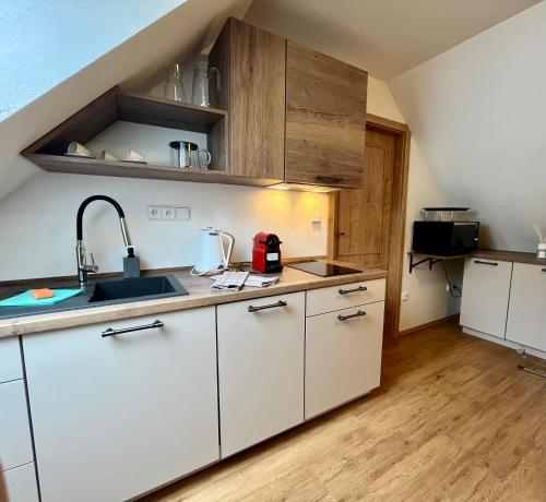 a kitchen with white cabinets and a sink at Chata Hubertka Krkonoše in Vítkovice