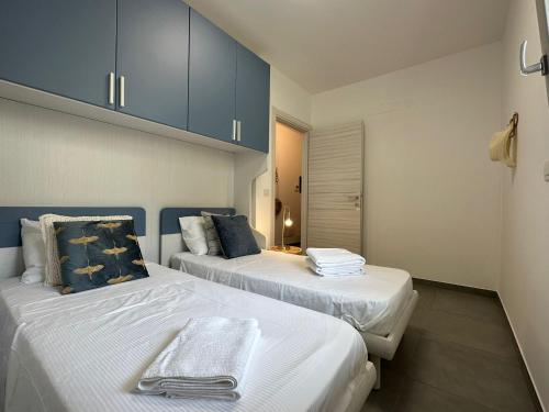 deux lits dans une chambre avec des armoires bleues dans l'établissement Residence Eucalyptus-San Remo-Free Parking, à Sanremo