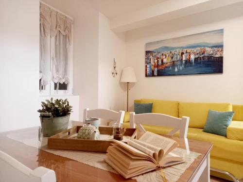 a living room with a table and a yellow couch at Apartment Megi in Supetar historical core in Supetar