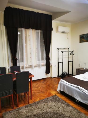 1 dormitorio con 1 cama, mesa y sillas en Baross-hat 5 en Szolnok