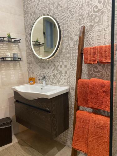 a bathroom with a sink and a mirror at Ta Serafina studio apartment with loft in Għajnsielem