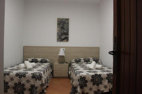 a hotel room with two beds and a lamp at Villa Piscis in Cala Blanca