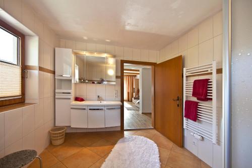 uma pequena cozinha com um lavatório e um espelho em Ferienwohnungen Ehammer em Stumm