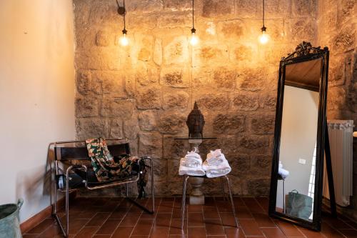 a mirror and pair of shoes on a chair in front of a wall at Torre Di Vico Residenza D'Epoca in Viterbo