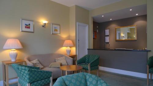 a waiting room with a couch and chairs and a mirror at St Clair Hotel in Thurso