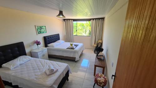 a small bedroom with two beds and a window at EcoCasa Rio Sauípe 200 m da Praia in Porto de Sauipe