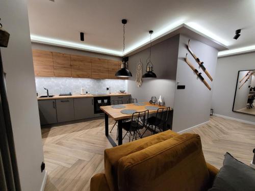 uma cozinha e sala de jantar com mesa e cadeiras em Apartament Wiślańskie Skije em Wisla