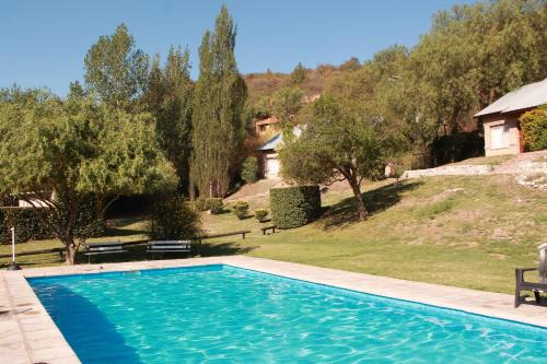 拉庫布蕾的住宿－Los Cerezos，一座位于庭院的游泳池,庭院里种着树木,房子里
