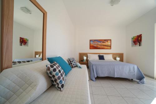 1 dormitorio con 2 camas y un espejo grande en Hotel Damanse, en Santa Domenica