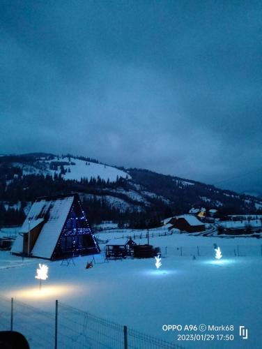 a snow covered slope with a tent in the snow at night at A Frame Alpin in Vatra Dornei