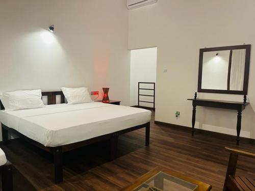 een slaapkamer met een groot bed en een spiegel bij Mario River Villa in Ambalangoda