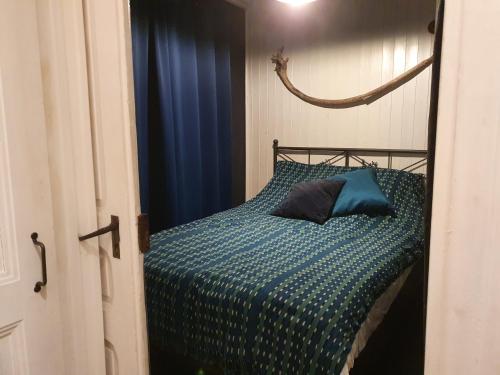 een slaapkamer met een bed met een blauw dekbed bij A Room with a View - Maisonnette dans bourg médiéval au bord du Lac Léman in Yvoire