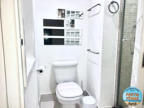 a small bathroom with a toilet and a shower at Flat Capitania em Pitangueiras perto da praia in Guarujá