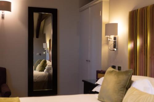 a hotel room with a mirror and a bed at Beechfield House in Beanacre