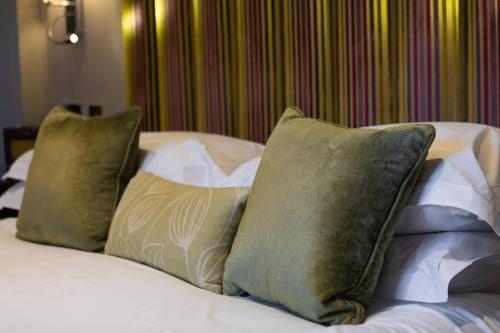 a bed with four pillows on top of it at Beechfield House in Beanacre