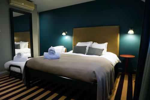 a hotel room with a large bed with blue walls at The Penny Farthing Hotel in Berkhamsted