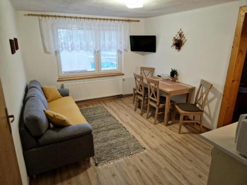 a living room with a couch and a table at Apartmány Grobarčík in Zuberec