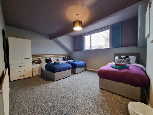 a bedroom with two beds and a window at Stylish base on Abbeydale Road in Sheffield