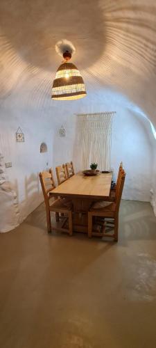 a wooden table and chairs in a room with a ceiling at Cuevas Los Coloraos - La Residencia in Villanueva de las Torres
