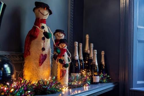 a group of three stuffed teddy bears and wine bottles at Beechfield House in Beanacre