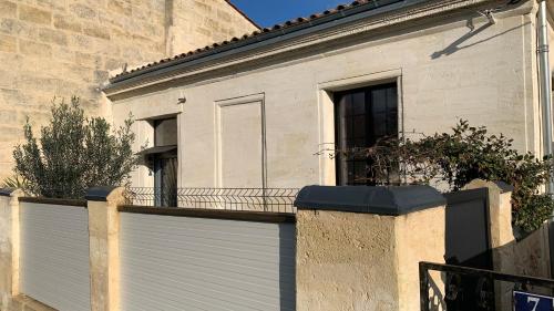 a white house with a garage door and a window at Maison entière - 2 chambres doubles in Lormont