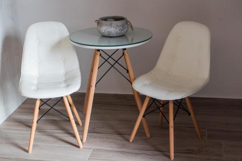 two white chairs and a table with a bowl on it at Langi Apartments in Mesolongion
