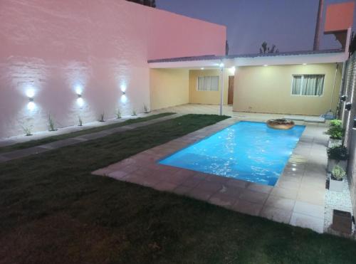 una piscina frente a una casa por la noche en Beige House en San Rafael