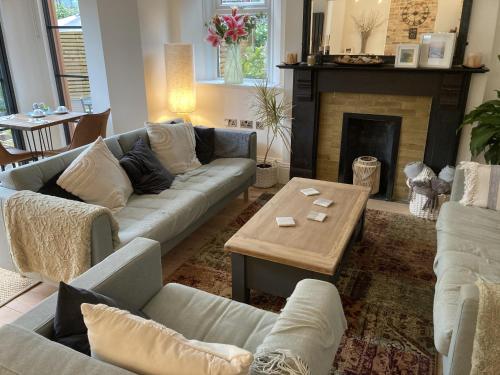 a living room with couches and a table and a fireplace at Summer Breeze in Newquay