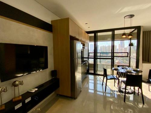 a living room with a table and a dining room at Estúdio Completo com Linda Vista no Ed. Vertigo in Campo Grande