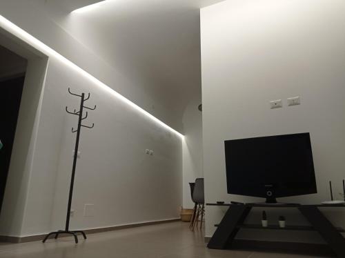 a living room with a tv and a cross on the wall at Nonna Sicula in Agrigento
