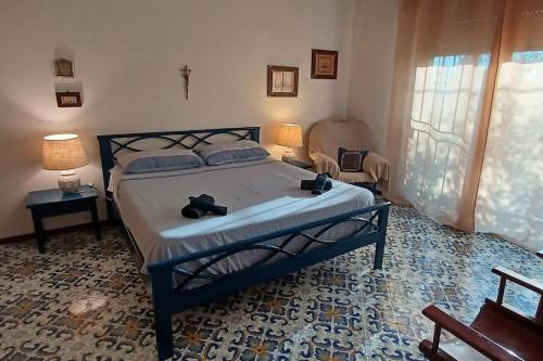 ein Schlafzimmer mit einem Bett mit zwei Schuhen drauf in der Unterkunft Giardino Mediterraneo in Ischia