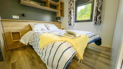 um quarto com uma cama com um cobertor amarelo e azul em Le Domaine De Mesqueau em Plougasnou